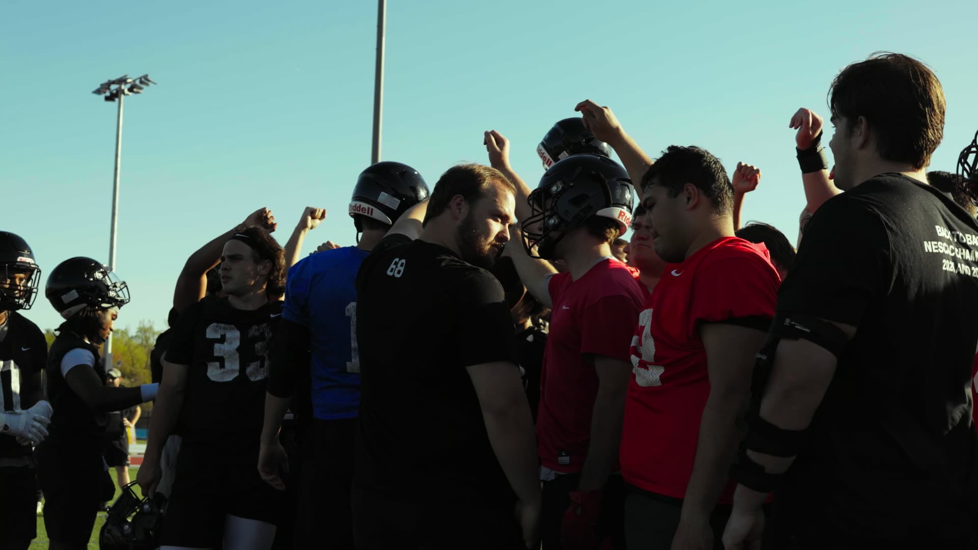 Wesleyan Football players and coaches in a huddle after practice